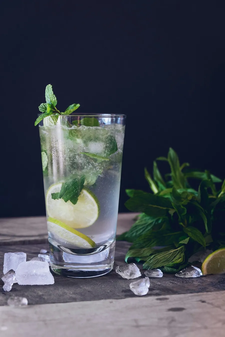 Verre d'eau pétillante avec citron vert, menthe et glaçons